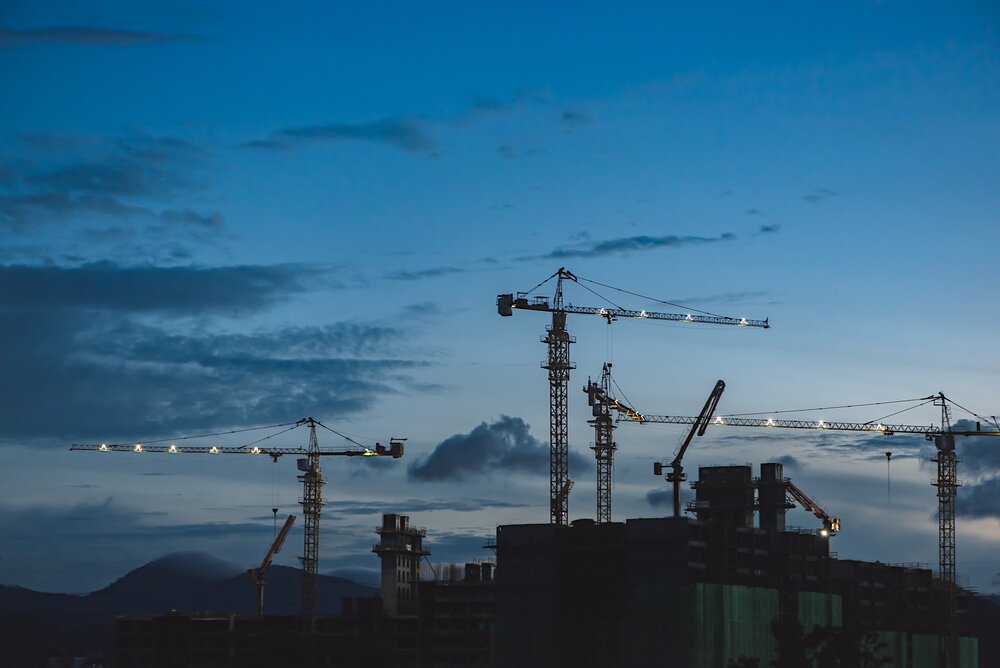 Cranes within industrial setting at dusk